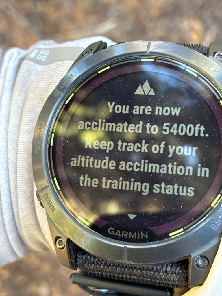 Picture of Garmin watch face with message that reads "You are now acclimated the 5400 ft. Keep track of your altitude acclimation in the training status..."