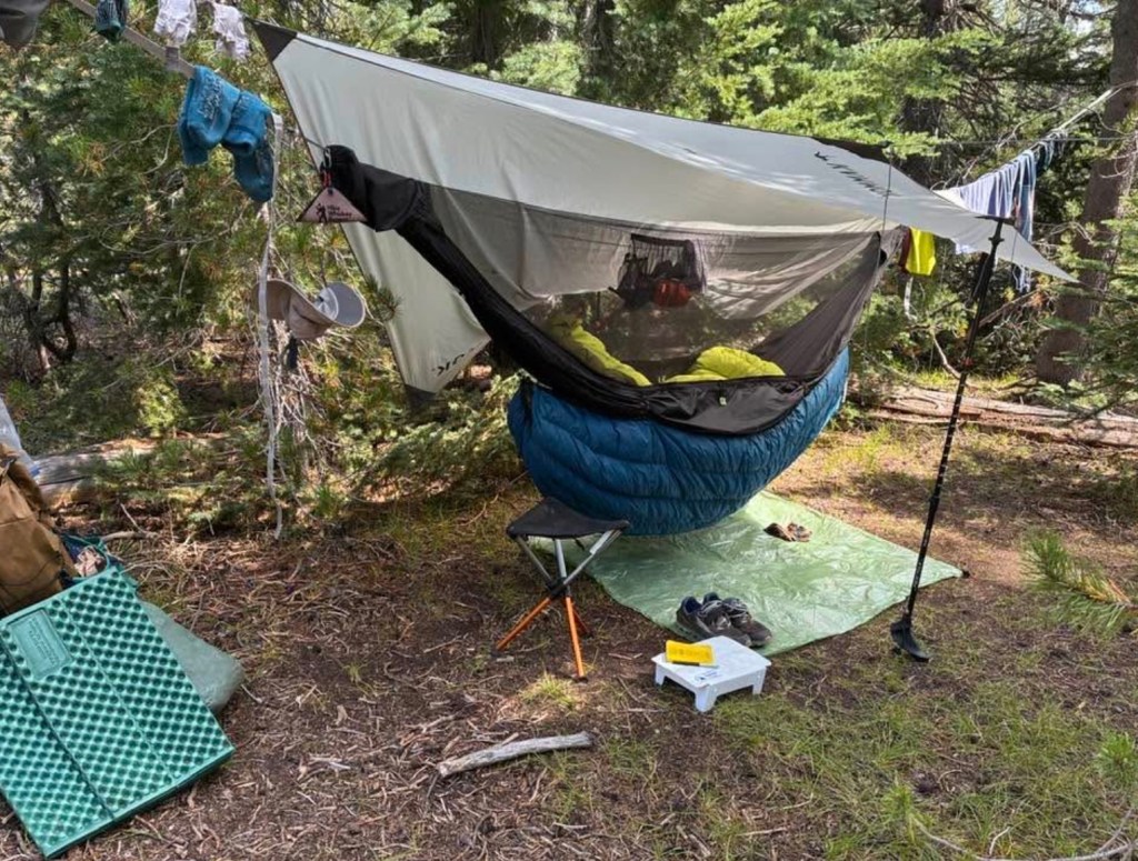 Camp site with a hammock, ground cloth, and a camp stool